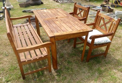 Lot 665 - A teak patio set, comprising table, single...
