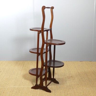 Lot 658 - A 1930s mahogany folding cake stand, h.90cm