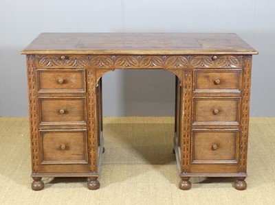 Lot 622 - A joined oak kneehole writing desk, with tan...