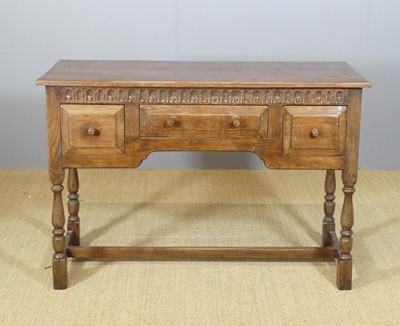 Lot 621 - A joined oak kneehole three-drawer side table...