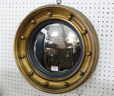 Lot 613 - A small giltwood convex wall mirror, in the...