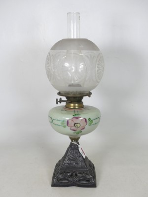 Lot 10 - An early 20th century oil lamp, having an acid-...