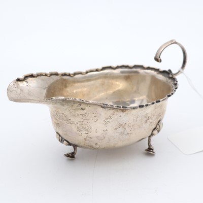 Lot 256 - A George V silver sauceboat, having a wavy rim...