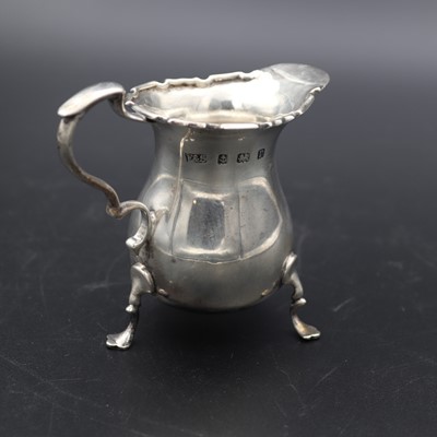 Lot 265 - A George V silver cream jug, having a wavy rim,...