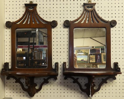 Lot 619 - A pair of mahogany fret-cut mirrored wall...