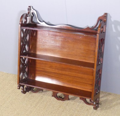 Lot 654 - A mahogany three-tier wall shelf, having...