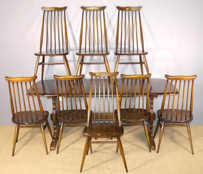 Lot 683 - An Ercol dark elm dining suite, comprising a...