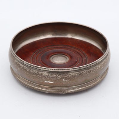 Lot 233 - An Elizabeth II silver-mounted bottle coaster,...