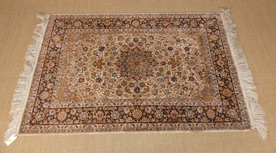 Lot 242 - A Kashan woven silk rug, the cream ground...