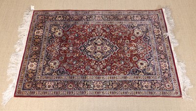 Lot 236 - A Persian woven silk Kashan rug, having a red...