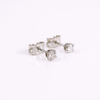 Lot 323 - A pair of white metal diamond ear studs, each...