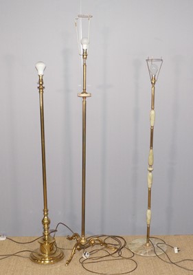 Lot 581 - A collection of three brass and onyx floor lights