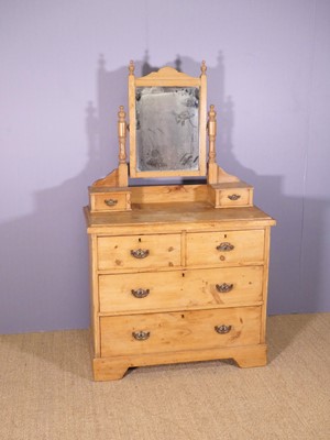 Lot 633 - An Edwardian pine swing mirror back dressing...