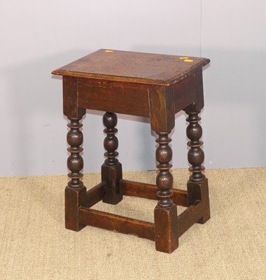 Lot 667 - A joined oak stool, raised on turned and...